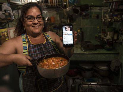 Yuliet Colón posa com a comida que preparou e seu telefone com sua página de cozinha de Facebook em sua casa em Havana, Cuba, o 2 de abril.