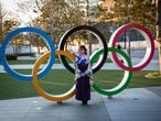 (FILES) In this file photo taken on March 25, 2020 a woman wearing a traditional Japanese kimono poses next to the Olympic rings in front of the Japan National Stadium, the main venue for the Tokyo 2020 Olympic Games, in Tokyo. (Photo by Behrouz MEHRI / AFP)