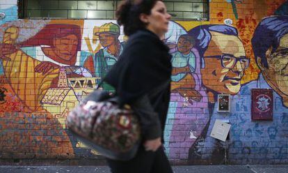 Mulher passa por grafite em Buenos Aires nesta sexta-feira.