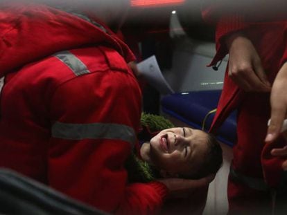 Equipe do Crescente Vermelho atende criança durante a operação de evacuação de Guta