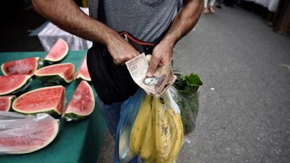 Um homem faz compras em uma feira em Caracas, na Venezuela.