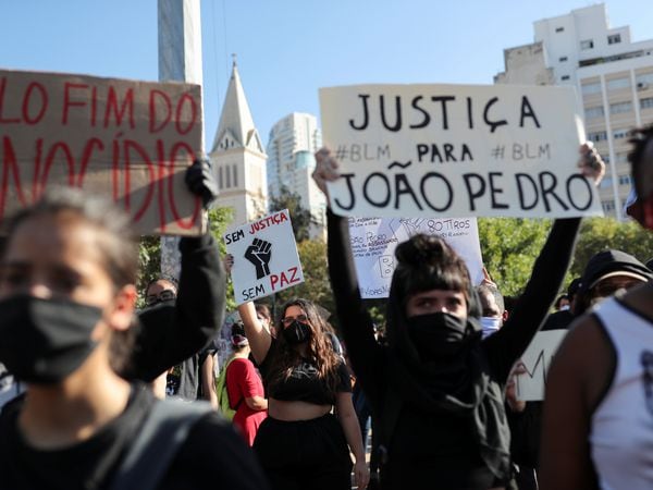 People hold up signs as they attend a protest against racism during a demonstration against Brazilian President Jair Bolsonaro and in support of democracy in Sao Paulo, Brazil June 7, 2020. REUTERS/Amanda Perobelli