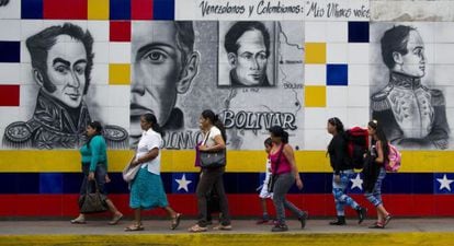 Pessoas caminham ante um mural no Estado de Táchira.