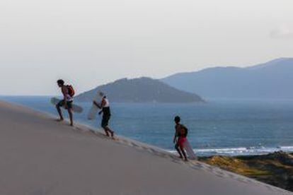 Praticantes de 'sandboard' na praia de Joaquina, em Santa Catarina (Brasil).