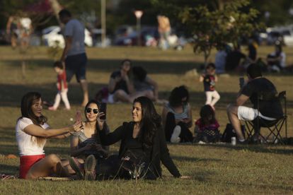 People gather in the late afternoon to watch the sunset at a park in the city center, after authorities eased restrictions related to COVID-19, in Brasilia, Brazil, Saturday, July 4, 2020. (AP Photo/Eraldo Peres)