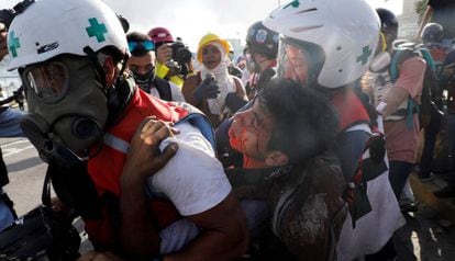 Paramédicos transportam um manifestante opositor ferido.