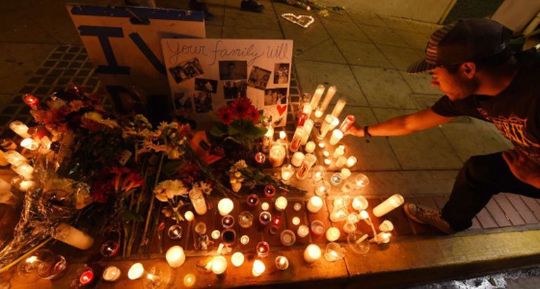 Um estudante deixa uma vela pelas vítimas do massacre.
