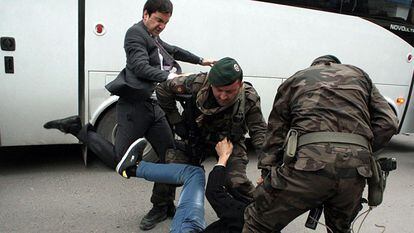 Um assessor de Erdogan chuta um manifestante detido por policiais.