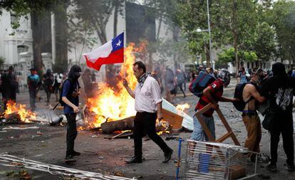 Um homem segura uma bandeira do Chile nos protestos de Santiago, na última sexta-feira