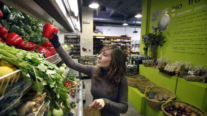 Uma mulher compra vegetais ecológicos.