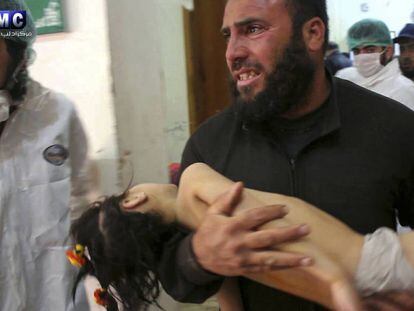 Homem leva menina nos braços ao pronto-socorro na localidade atacada com armas químicas.