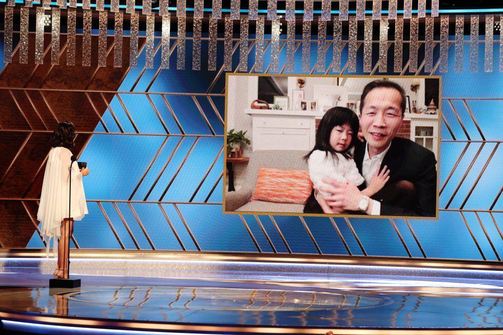Lee Isaac Chung recebe de maneira virtual, com sua filha nos braços, o Globo de Ouro. 