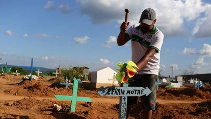 Familiar coloca cruz para identificar o túmulo de uma das vítimas da chacina em Altamira.