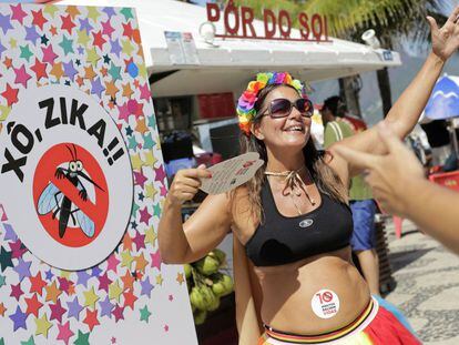 Uma gr&aacute;vida dan&ccedil;a ao lado de cartaz contra o zika no Carnaval do Rio.