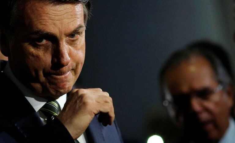 Bolsonaro com Guedes ao fundo.