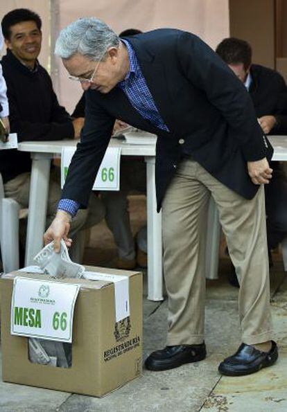 O ex-presidente Álvaro Uribe deposita seu voto na urna.