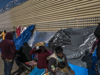 Um grupo de imigrantes aguarda em um acampamento improvisado diante do muro fronteiriço em San Luis Rio Colorado, no Estado de Sonora.