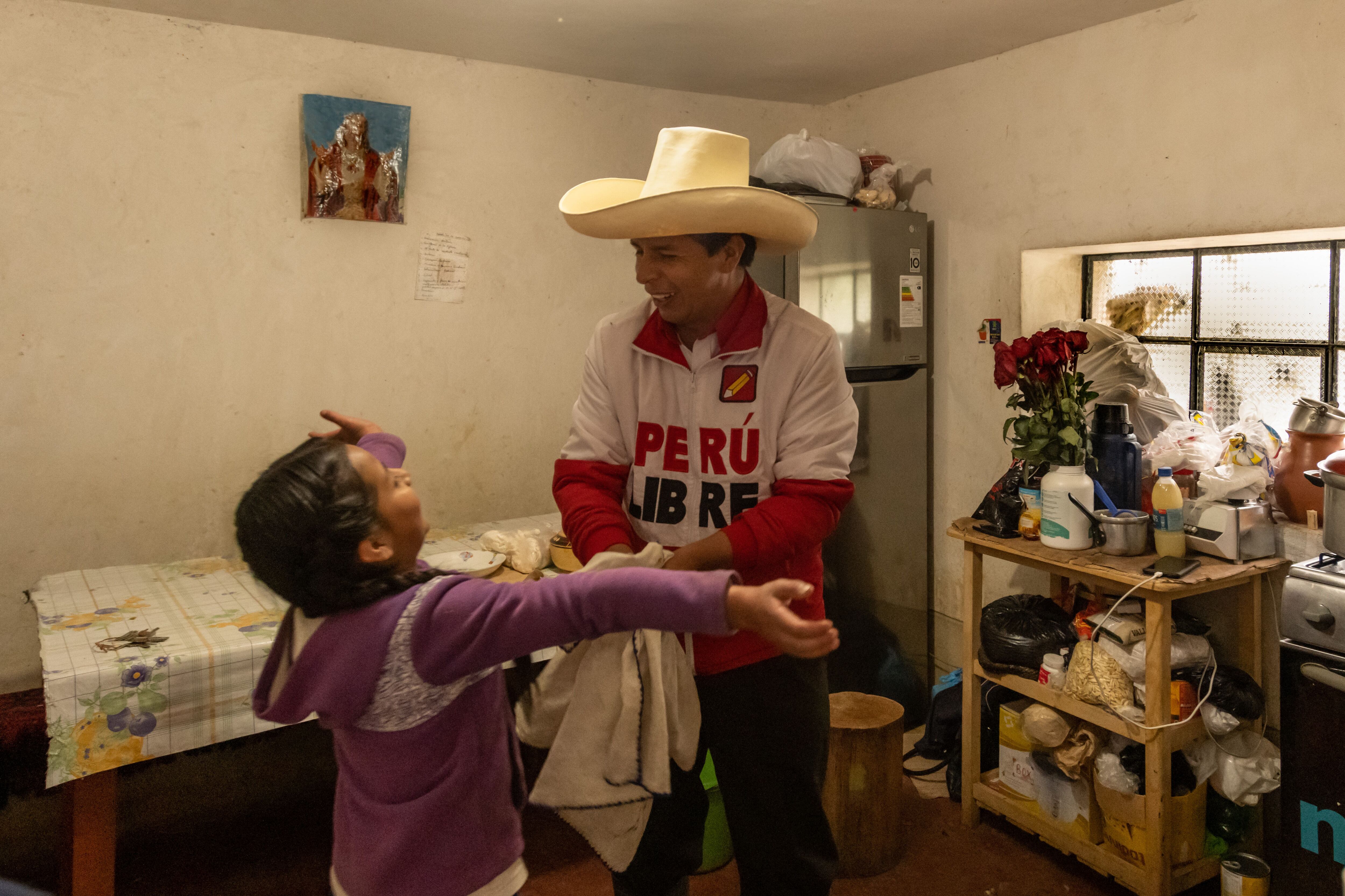 Pedro Castillo na cozinha de sua casa em Chugur, Chota, com sua filha mais nova, Alondra, de nove anos