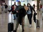 Viajeros procedentes de Italia protegidos con mascarillas a su llegada al aeropuerto de Manises (Valencia).