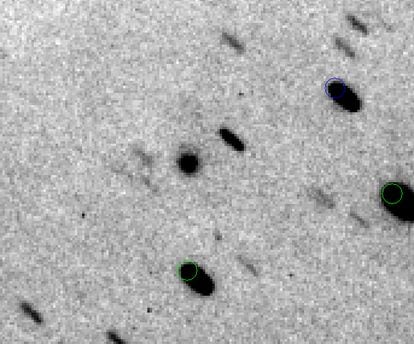 O cometa 2014 UN271 (o círculo do centro da imagem), cercado de estrelas, que aparecem alongadas pelo movimento do telescópio.