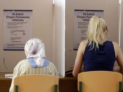 Duas lituanas preenchem suas cédulas para as eleições europeias em Riga.