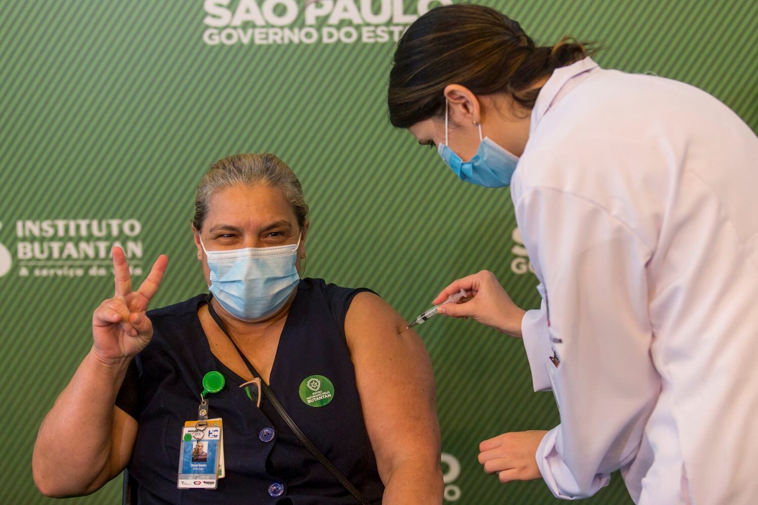 Mulher comemora ao tomar a vacina contra a covid-19 no Hospital das Clínicas de São Paulo, Brasil, neste domingo.