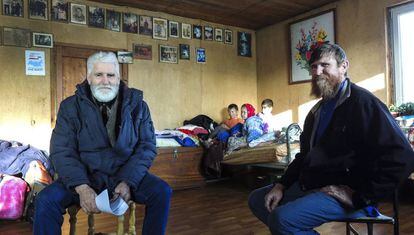 Fedor Kronikovski (à esquerda) conversa com Ulian Murashov (à direita). Ao fundo, os dois filhos da família, Agripina e Filaret, junto a outra criança.