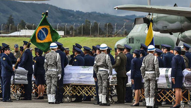 Militares colombianos preparam a partida de caixões das vítimas ao Brasil.