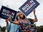 TOPSHOT - Two women holding Biden/Harris lawns signs take a selfie at a rally with Democratic Senate candidates Rev. Raphael Warnock and Jon Ossoff on October 24, 2020, in Duluth, Georgia. - Neighbors and volunteers are handing out water and snacks to the masked voters waiting patiently in line to cast their ballots on a hot October day in the Atlanta suburb of Smyrna.
Americans go to the polls on November 3 but the enthusiastic early voting here has already given the morning an air of Election Day.
Georgia has been a reliably Republican, conservative bastion and a Democrat has not won in the Peach State since Bill Clinton, a fellow Southerner, in 1992.
But Democratic candidate Joe Biden, 77, and Republican incumbent Donald Trump, 74, are running neck-and-neck in the polls in Georgia. (Photo by Elijah Nouvelage / AFP)