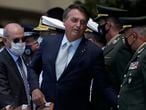 Brazil's President Jair Bolsonaro, accompanied by Defense Minister Fernando Azevedo, left, arrives to attend a ceremony to commemorate the 80th anniversary of the Air Force, at the Air Base headquarters in Brasilia, Brazil, Wednesday, Jan. 20, 2021. (AP Photo/Eraldo Peres)