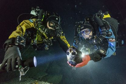Os mergulhadores Alberto Nava e Susan Bird com o crânio de uma menina de 12.000 anos, descoberto em uma gruta alagada do Yucatán.