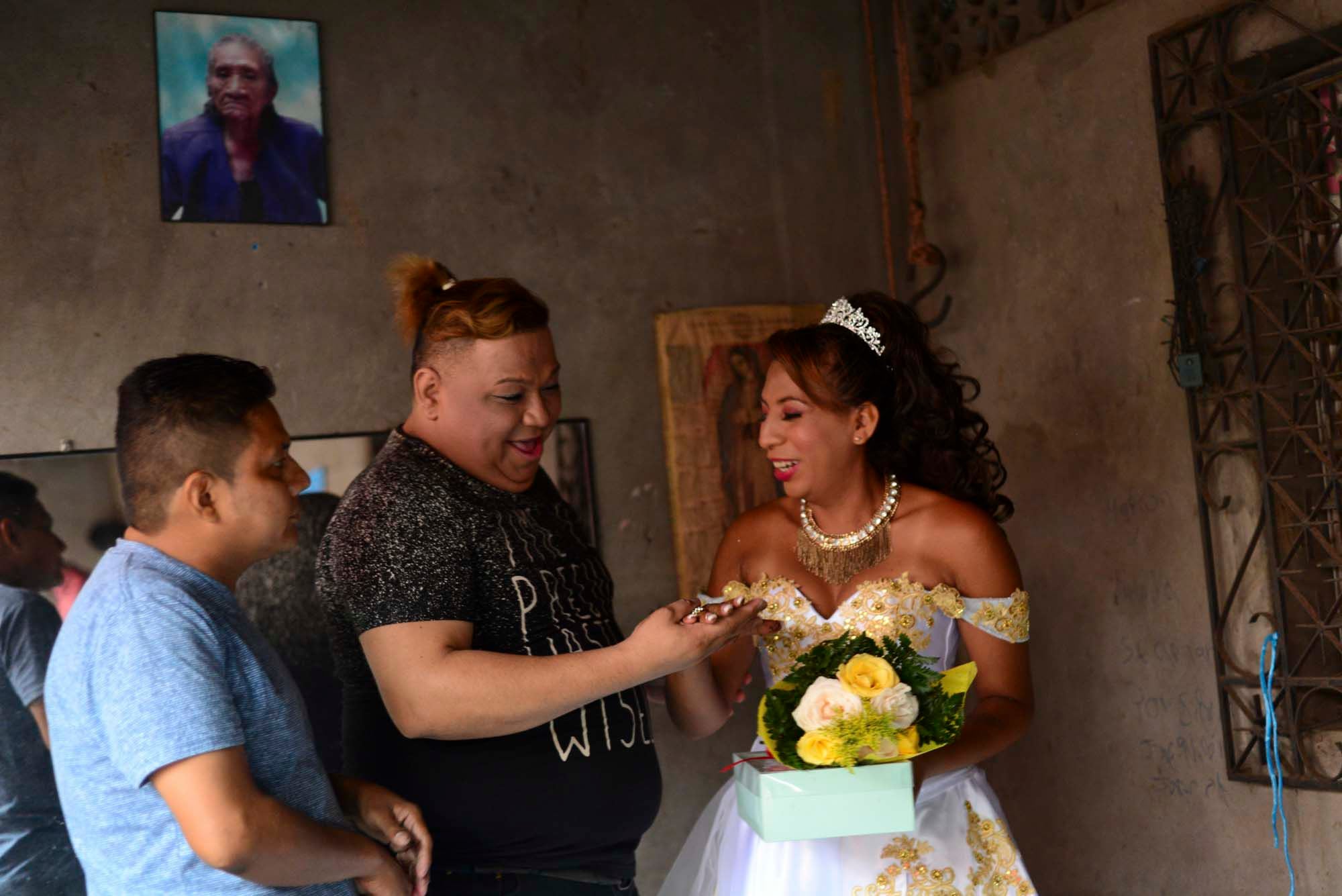 Membros da comunidade se surpreendem com a aliança de “casamento” de Valentina, embaixo de um retrato de sua avó. 