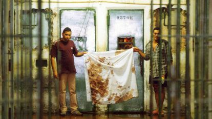 Detentos mostram panos sujos de sangue após o massacre, em outubro de 1992. 