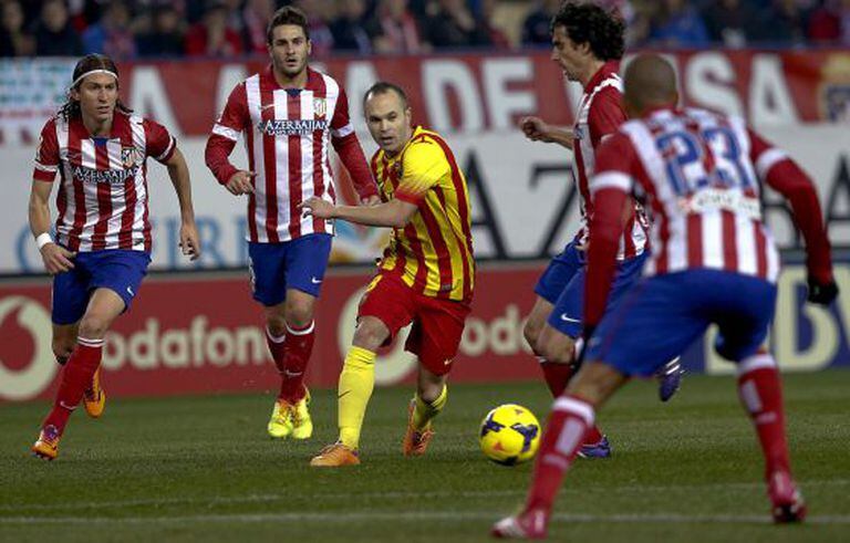 Iniesta conduz a bola entre jogadores do Atlético.