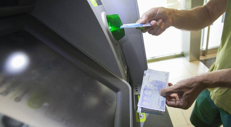 Usuário retira dinheiro de um caixa eletrônico em Madri.