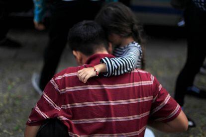 Menina abraça seu pai após sua deportação do México a San Salvador.