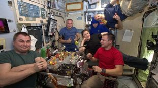 Astronautas compartilham uma refeição a bordo da Estação Espacial Internacional.