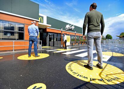 Clientes mantêm a distância social recomendada para entrar num McDonald’s dos Países Baixos.