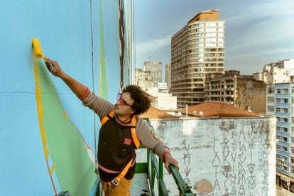 Tutano Nomade trabalha em um guindaste pintando um paredão no  centro histórico de São Paulo, dentro de um projeto municipal. 