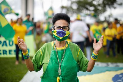 Uma manifestante vestida de máscara com a bandeira do Brasil, neste domingo, em Brasília.