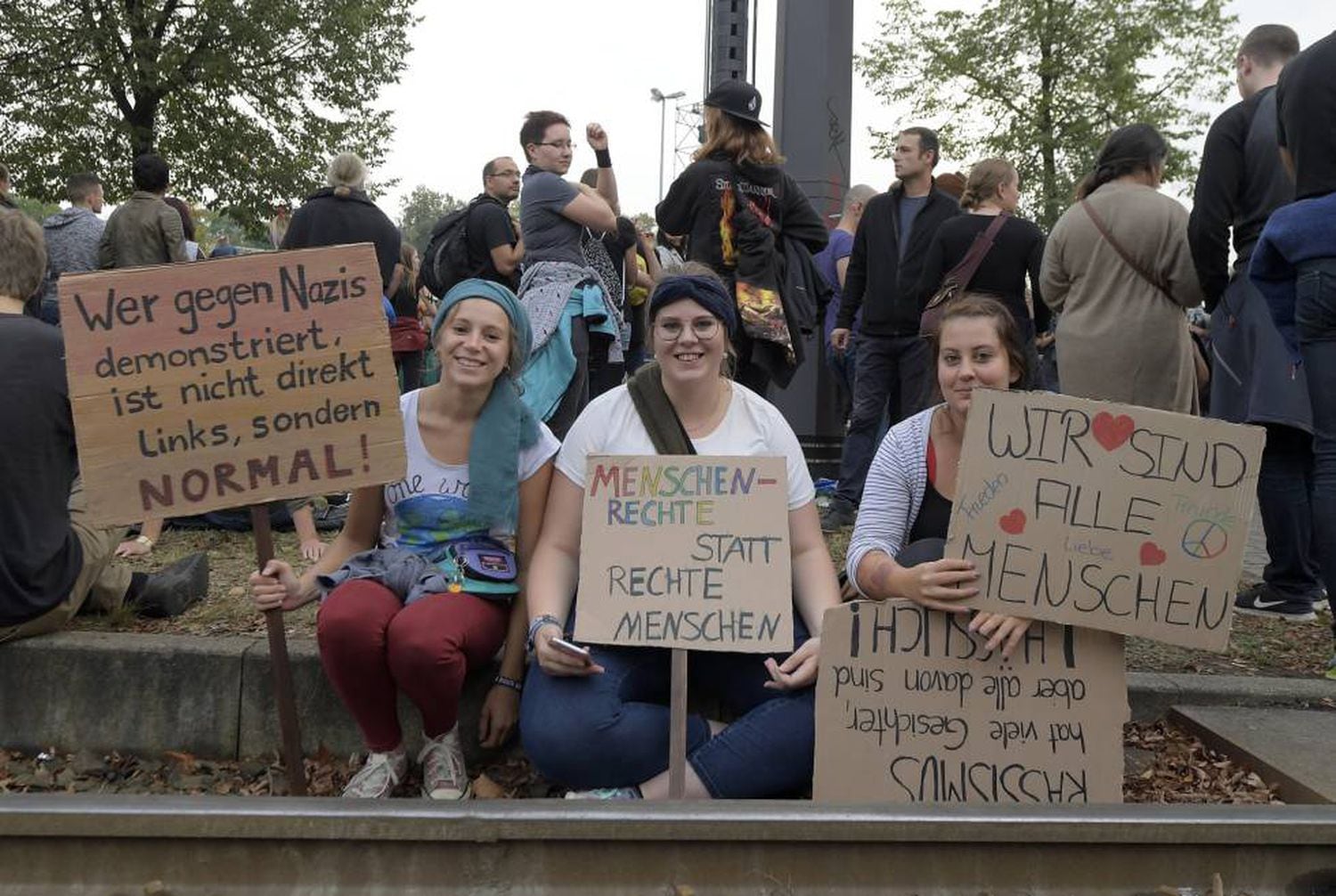 "Quem protesta contra os nazistas não é de esquerda, mas normal"; "direitos humanos ao invés de humanos de direita" e "nós somos todos humanos", nos cartazes em protesto em Chemnitz, na Alemanha, no dia 3 de setembro.