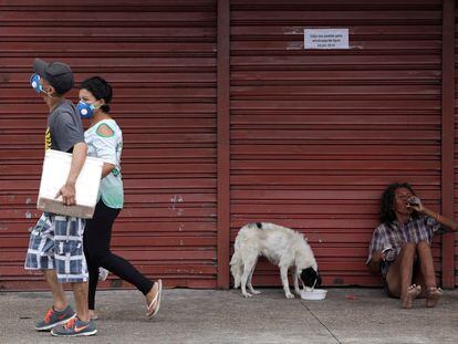 Pessoas com máscaras protetoras andam durante o surto de doença de coronavírus, perto do Porto de Manaus.