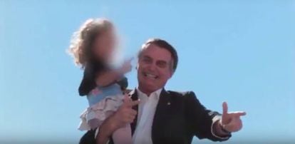 Durante a campanha, Bolsonaro ensina criança a simular arma com a mão.