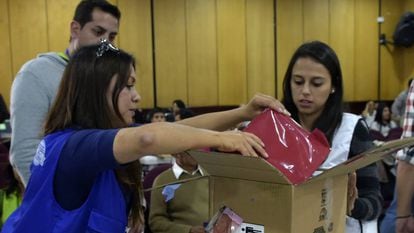 Funcionários da autoridade eleitoral abrem uma caixa com atas da eleição presidencial em Quito.