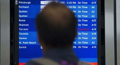 Um homem consulta a lista de voos no aeroporto da Filadélfia.
