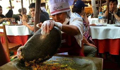 Cozinheira esmaga alimentos num ‘batán’ no restaurante La Nueva Palomino, em Arequipa.