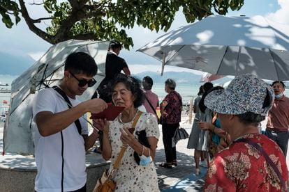 Turistas chineses são vistos na praia de Dapeng Jiaochangwei, na província de Guangdong, sul da China. 