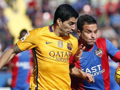 O zagueiro do Levante "Toño" García, à direita, com a bola, ao lado do atacante uruguaio do Barcelona, Luis Suárez.