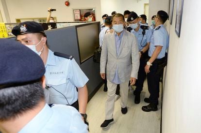 O empresário Jimmy Lai, no centro, escoltado pela polícia na redação do ‘Apple Daily’, nesta segunda-feira, em Hong Kong.