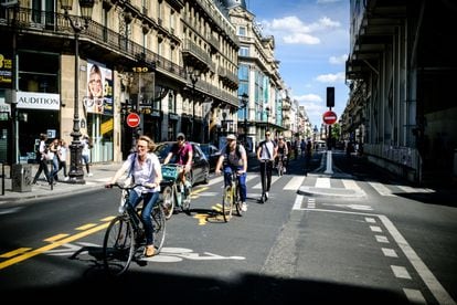 Parisienses percorrem a Rue de Rivoli de bicicleta.